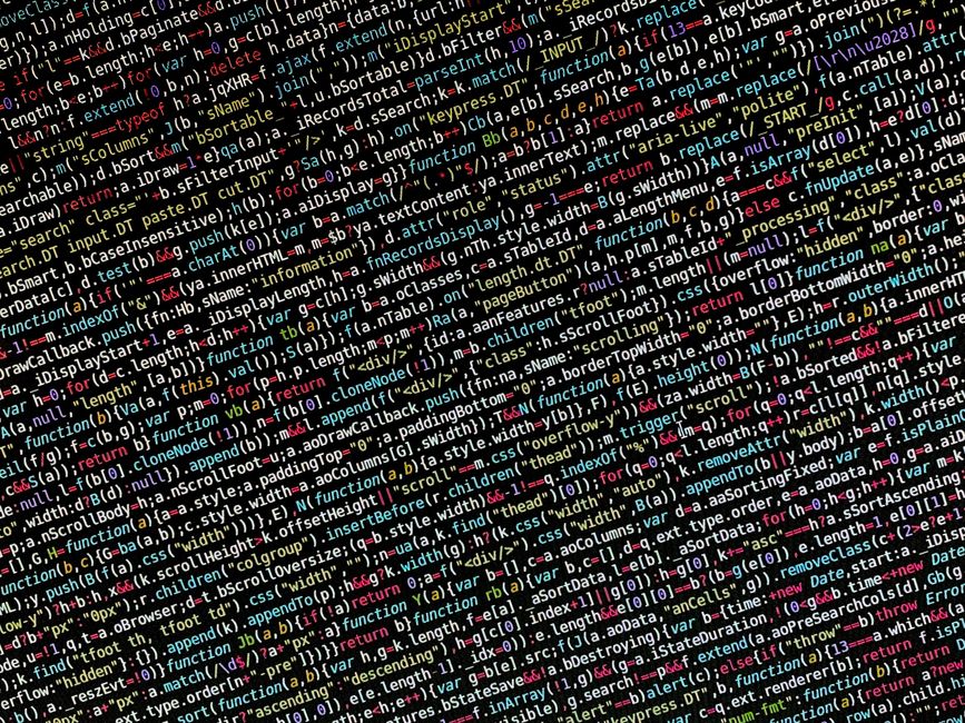 The image displays a computer screen showing a close-up of a code editor with lines of JSON-like text in various colors, including red, green, blue, and purple, on a dark background. The code appears 